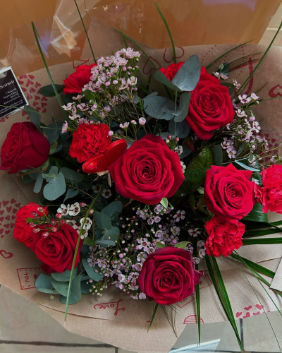 Smooch - 6 red roses and 6 red carnations with choice filler and foliage in a hand-tied or arrangement  in Oasis and presented in a gift bag or box.